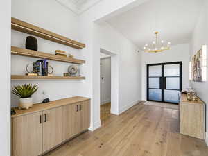 Entrance foyer featuring light wood finished floors and suspended lighting