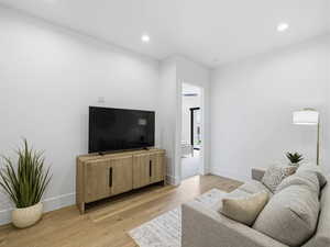 Living area featuring light wood finished floors and recessed lighting