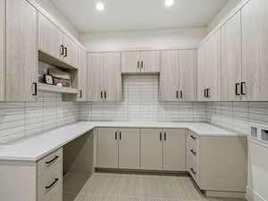 Kitchen featuring open shelves, light stone countertops, tasteful backsplash, recessed lighting, and light wood finish cabinets