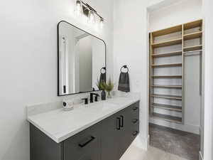 Bathroom with vanity and a walk in closet