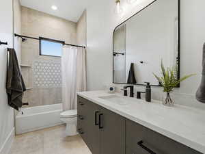 Bathroom featuring vanity, shower / tub combo with curtain, and recessed lighting