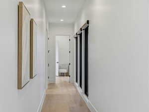 Hall with light wood-style flooring and recessed lighting