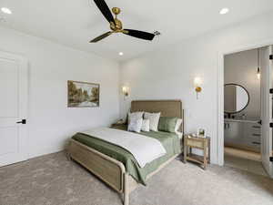 Carpeted bedroom featuring a ceiling fan, ensuite bathroom, and recessed lighting