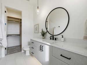 Bathroom with vanity, light tile patterned floors, and a spacious closet