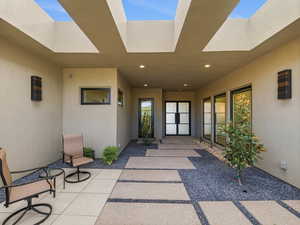 Doorway to property with stucco siding and a patio
