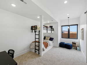 Bedroom with light carpet, recessed lighting, and a desk