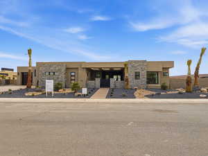 View of front of home featuring stucco siding and stone siding