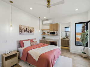 Bedroom featuring light wood-type flooring, recessed lighting, ceiling fan, ensuite bath, and wine cooler