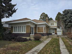 View of front facade featuring brick siding, a chimney, and a front yard