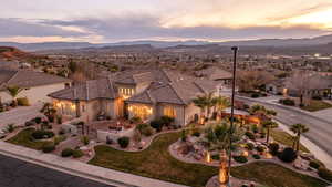 View of front facade with stucco siding, a mountain view, a residential view, a tile roof, and a patio area