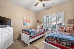 Carpeted bedroom with ceiling fan and baseboards