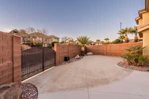 Fenced backyard with a gate and a patio area