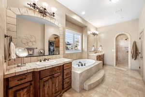 Bathroom with two vanities, walk in shower, and a bath
