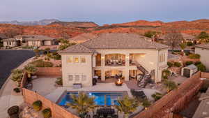 Rear view of property with a balcony, a fenced backyard, a patio area, stucco siding, and a mountain view