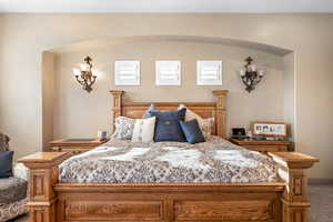 Carpeted bedroom featuring arched walkways