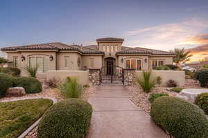 Mediterranean / spanish-style home featuring a gate, stucco siding, a fenced front yard, a tile roof, and a patio