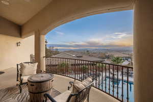 Balcony at dusk with view of pool and a mountain view