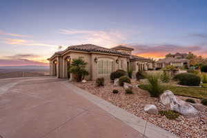 Mediterranean / spanish-style house with stucco siding, concrete driveway, a tile roof, and a garage
