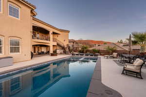 Relaxing pool / spa with a patio, a fenced backyard, a balcony, an outdoor living / dining area, and an outdoor fire pit