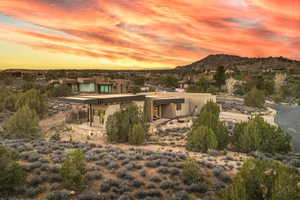 Back of house at dusk featuring stucco siding, a patio area, and a mountain view