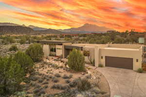 View of front facade with stucco siding, concrete driveway, a garage, and a mountain view