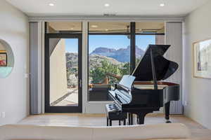 Living area with a mountain view, healthy amount of natural light, light wood finished floors, and recessed lighting