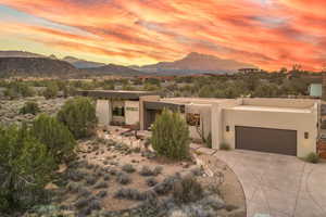 View of front of property featuring stucco siding, a garage, concrete driveway, and a mountain view