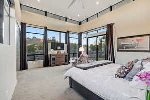 Bedroom with a high ceiling, light colored carpet, a ceiling fan, and recessed lighting