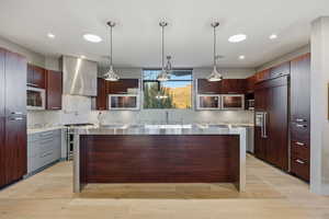 Kitchen featuring a center island, stainless steel appliances, light wood-style floors, and modern cabinets