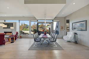 Dining area featuring plenty of natural light, recessed lighting, a glass covered fireplace, and light wood-style floors
