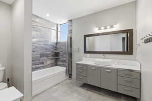 Bathroom featuring vanity and shower / bathtub combination with curtain