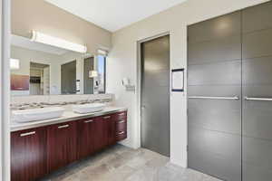 Bathroom with double vanity, backsplash, and a spacious closet