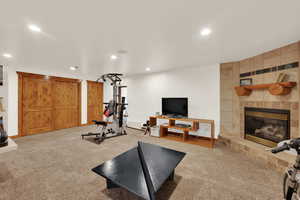Exercise area featuring carpet flooring, a fireplace, and recessed lighting