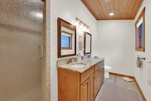 Full bath featuring a shower stall, double vanity, wood ceiling, and recessed lighting