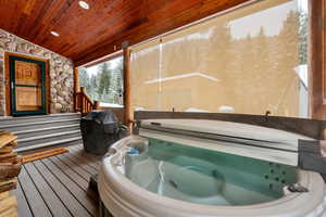 Sunroom with a jacuzzi, lofted ceiling, and a relaxing sauna