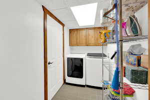 Laundry area with a paneled ceiling, cabinet space, and washer and dryer