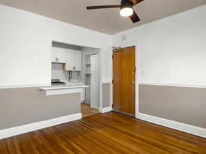 Kitchen featuring white cabinetry, a ceiling fan, dark wood finished floors, tasteful backsplash, and open shelves