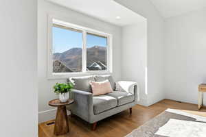 Sitting room with light wood-type flooring, a mountain view, and recessed lighting