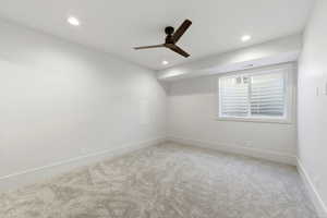 Empty room featuring light carpet, ceiling fan, and recessed lighting
