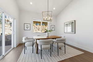 Dining area with hanging lights, healthy amount of natural light, and wood finished floors