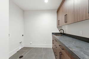 Laundry area with cabinet space, hookup for a washing machine, electric dryer hookup, and recessed lighting