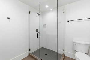 Full bath featuring toilet and a stall shower
