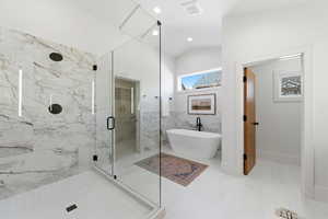 Full bath with a marble finish shower, a freestanding tub, tile walls, a wainscoted wall, and recessed lighting