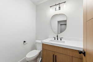 Half bathroom with vanity and toilet