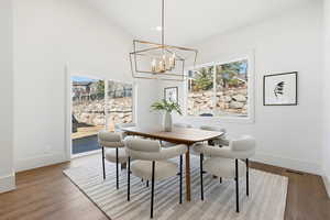 Dining area featuring a high ceiling, hanging lights, and light wood finished floors