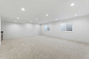 Empty room with light colored carpet and recessed lighting