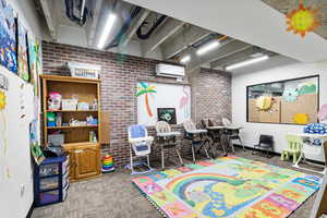 Game room with brick wall and a mini split for heating / cooling
