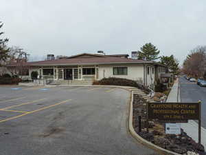 View of building exterior featuring uncovered parking and entry steps