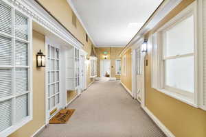 Hall featuring ornamental molding and carpet flooring