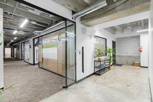 Interior space with concrete floors, a mini split for heating / cooling, and concrete block wall